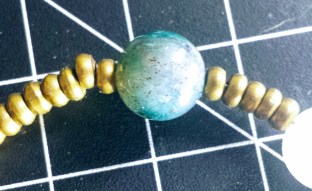 An image of the bead with red flecks in it.