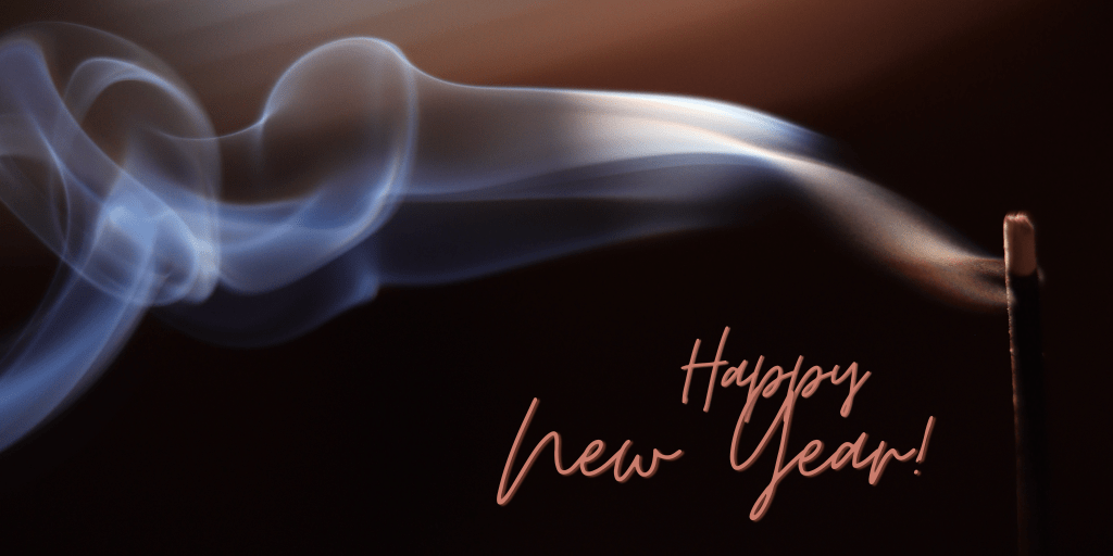 Incense burning, the smoke trailing towards the left. The text reads Happy New Year.